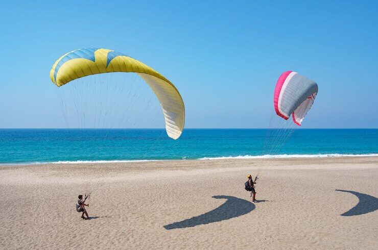 paraglider-tandem-flying-sea-shore-with-blue-water-sky-horison-view-paraglider-blue-lagoon-turkey_158595-6947